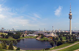 Der Olympiapark München mit Olympiastadion, Olympiahalle, Olympia-Schwimmhalle und Olympiaturm. Im Vordergrund der Olympiasee, im Hintergrund das BMW-Welt, BMW-Tower und die Allianz Arena.